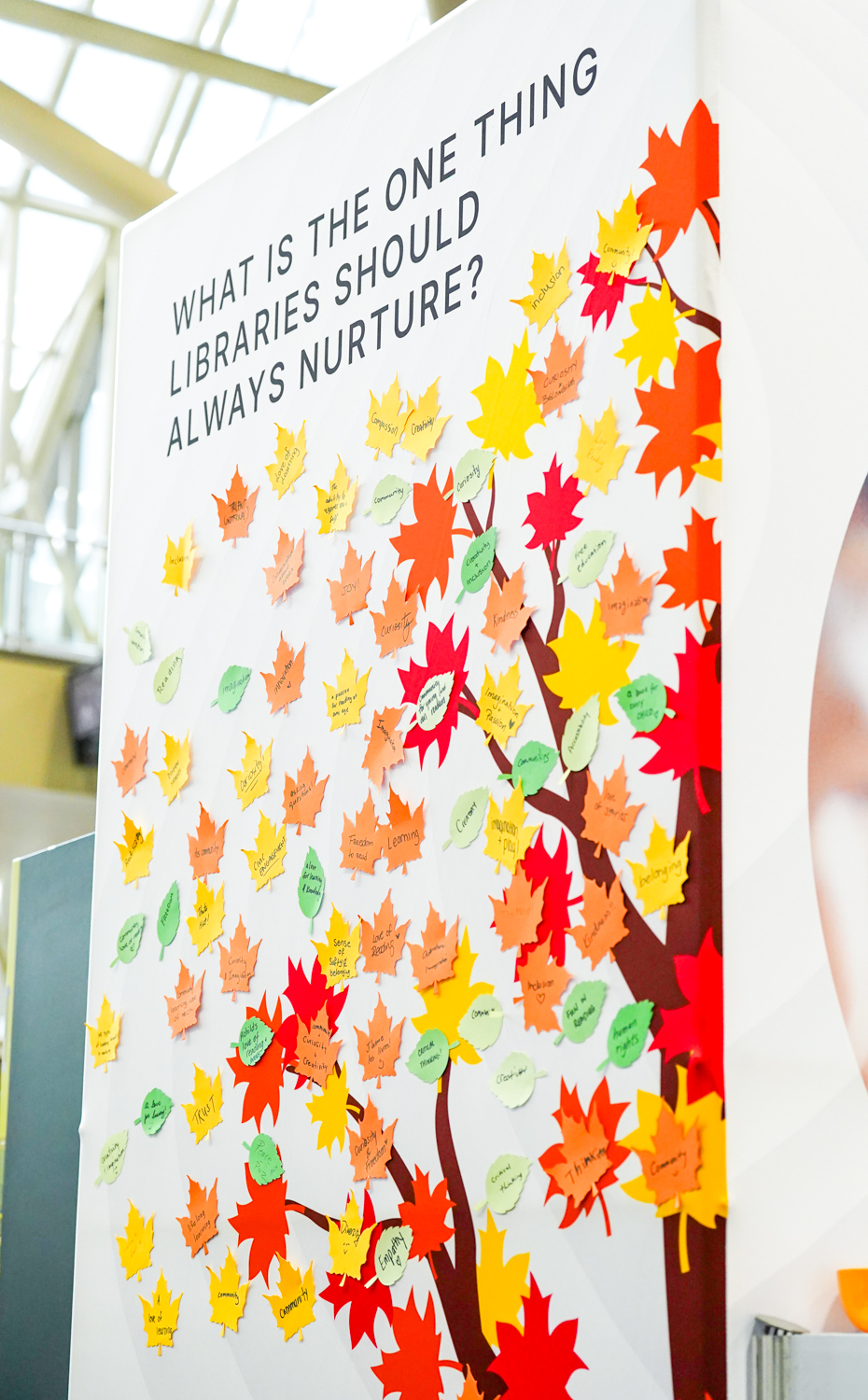 Image of sign with leaves where people can write "What is the one thing libraries should always nurture" from the SC26 expo floor.